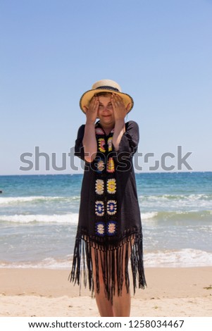  Beautiful young woman in the hat on the beach in summer. Sea and blue sky.