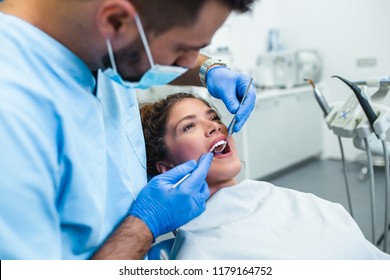 Beautiful young woman having dental treatment at dentist's office. 