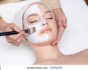 Beautiful young woman having a facial cosmetic mask at spa salon - Shutterstock ID 74751574