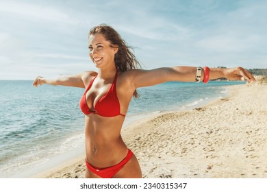 Beautiful young woman having fun and enjoying on the beach with open arms and looking away. - Powered by Shutterstock