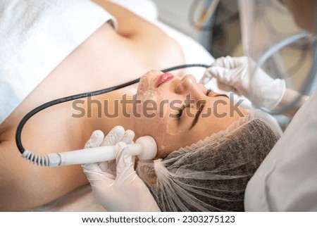 Beautiful young woman having Radio frequency skin tightening treatment in beauty clinic