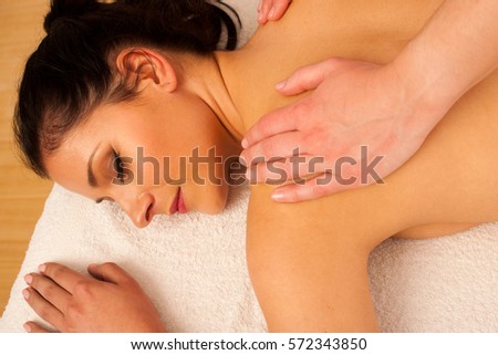 Beautiful young woman having a rejuvenating massage in a wellness studio - spa