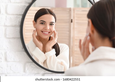 Beautiful Young Woman With Healthy Skin Looking In Mirror