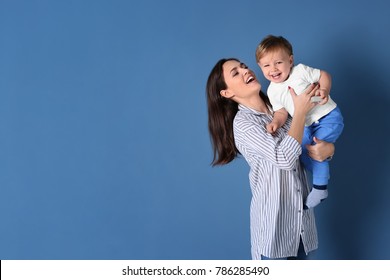 Beautiful Young Woman With Her Baby On Color Background