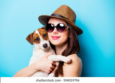 Beautiful Young Woman With Her Dog Standing In Front Of Wonderful Blue Background