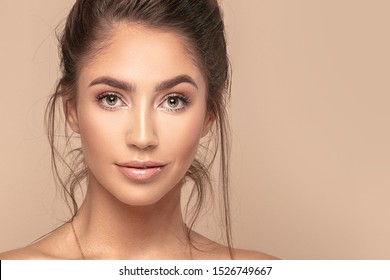 Beautiful young woman, her face, skin. Smiling young natural girl. Portrait of brunette lady with big eyes looking at camera.