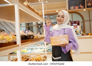 beautiful young woman hijab smiling proudly at her shop. attractive asian young female shopkeeper