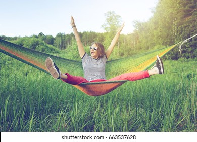 Beautiful young woman hippy on a hammock in a green summer field and forest, freedom, vacations, fun concept - Powered by Shutterstock