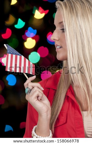 Beautiful young woman holding an American flag.