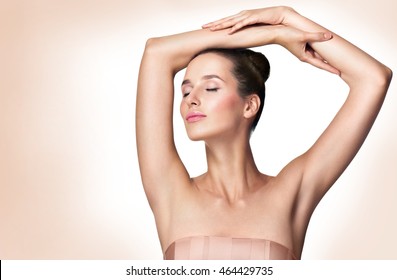 Beautiful young woman holding her arms up and showing clean underarms. Armpit's care. Armpit epilation, hair removal, perfect skin.