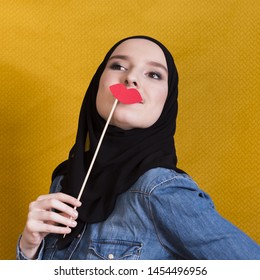 Beautiful Young Woman Holding A Photo Booth Prop In The Shape Of Red Lips