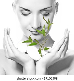 Beautiful Young Woman Holding Plant Growing Up Through Stones