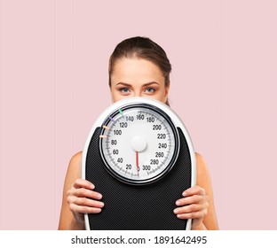 Beautiful Young Woman Holding Scales