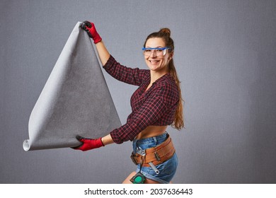 Beautiful Young Woman Holding Wallpaper Rolls. Professional Female Worker Holds A Wallpaper And A Roller In Hands. Girl Is Preparing To DIY Repair Or Painting.