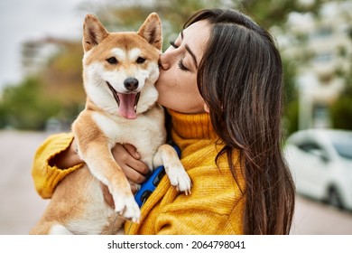 Beautiful Young Woman Kissing And Hugging Shiba Inu Dog At Street