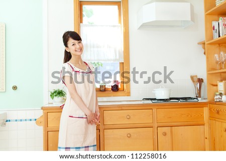 Beautiful young woman in the kitchen. Portrait of asian.
