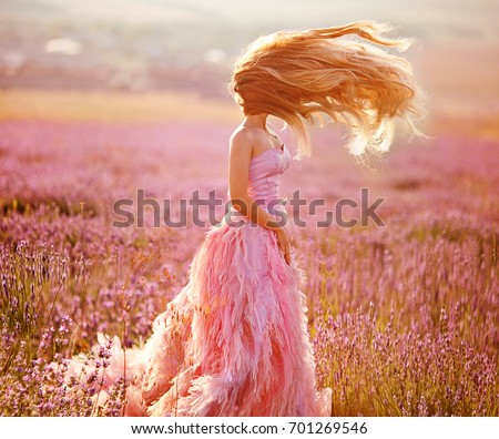 Beautiful young woman in the lavender fields. Pink skirt , a good mood . Provence .