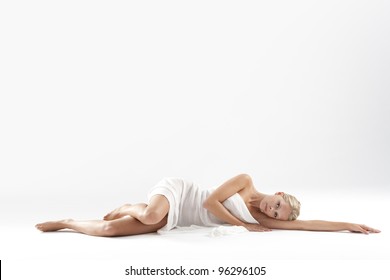 Beautiful Young Woman Laying Down With White Fabric Covering Her Body.