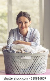 Beautiful Young Woman Is Leaning On The Basin With Laundry, Looking At Camera And Smiling