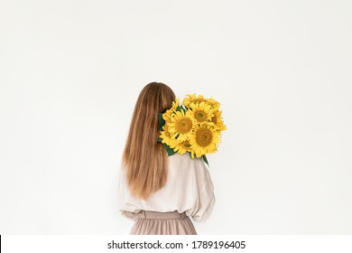 Beautiful young woman in linen dress holding sunflowers bouquet on white background. Autumn concept. - Powered by Shutterstock