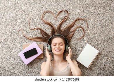 Beautiful young woman listening to audiobook at home