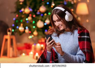 Beautiful Young Woman Listening To Christmas Music At Home