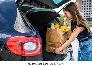 Beautiful Young Woman Loading Groceries Into Her Car