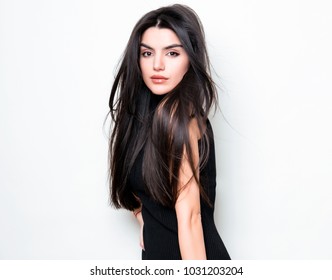 beautiful young woman with long black hair posing on white background