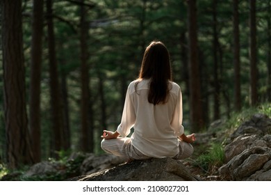 Beautiful young woman with long brunette hair meditates in nature, in a beautiful forest. Travel and healthy lifestyle, enjoying nature - Powered by Shutterstock