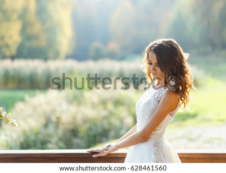 Beautiful young woman with long curly hair posing on terrace