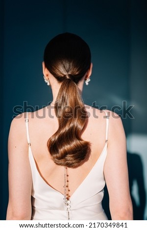 Beautiful Young Woman with Long Healthy and Shiny Smooth Hair. Bride with Hairstyle Low Ponytail, Back View