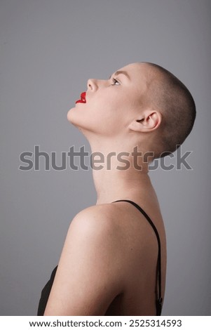 Similar – Portrait of a young, very short-haired woman wearing an off-the-shoulder top through which you can see her nipples