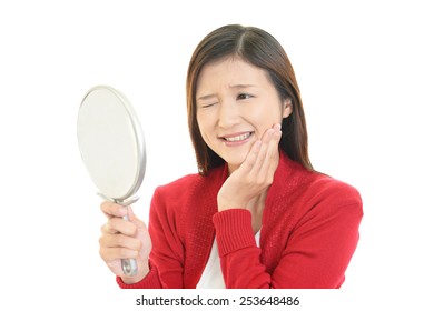 Beautiful Young Woman Looking At Herself In A Hand Mirror