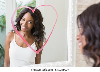 Beautiful Young Woman Looking In Mirror With Heart On It