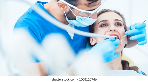 Beautiful young woman looking up relaxed during a painless dental procedure done by her reliable dentist in a modern clinic with sterile equipment - Powered by Shutterstock