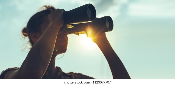 Beautiful Young Woman Looking Through Binoculars At The Sea On A Bright Sunny Day