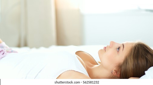 Beautiful young woman lying in bed comfortably and blissfully - Shutterstock ID 562581232