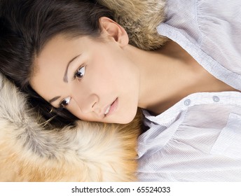 beautiful young woman lying in a fur