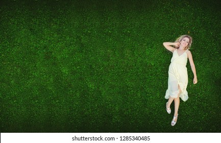 Beautiful young woman lying on the grass. Fresh natural summer concept. View from above. - image