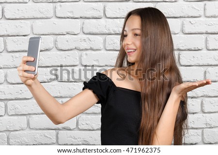 Beautiful young woman is making selfie photo with smartphone