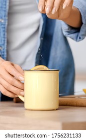 Beautiful Young Woman Making Tea With Lemon At Home, Closeup