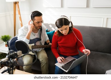 Beautiful Young Woman And Man Recording A Song. Duet Listening To Their Music And Rehearsing On A Recording Studio At Home