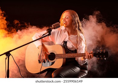 Beautiful young woman with microphone and guitar singing on dark background - Powered by Shutterstock