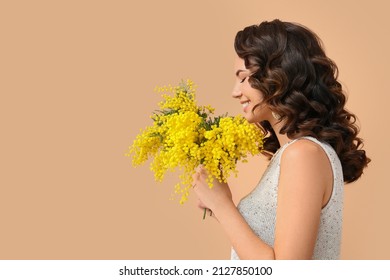 Beautiful young woman with mimosa flowers on color background - Powered by Shutterstock