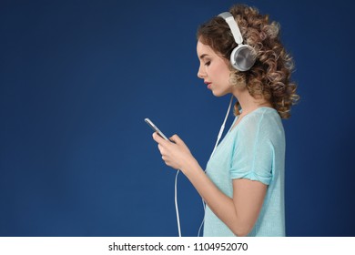Beautiful young woman with mobile phone listening to music on color background - Shutterstock ID 1104952070