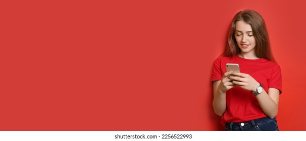 Beautiful young woman with mobile phone on red background with space for text - Shutterstock ID 2256522993