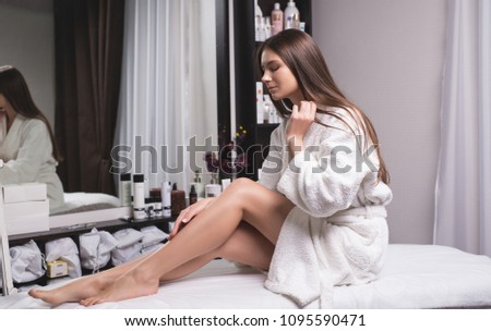 Beautiful young woman in a modern beauty salon showing her perfect slim legs