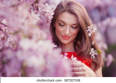 Beautiful Young Woman Near The Blossoming Spring Tree