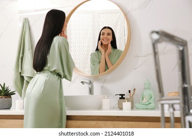 Hermosa joven mujer cerca del espejo en el baño