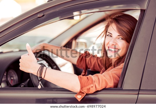 Beautiful young woman in the nice car is going
to vacation.
